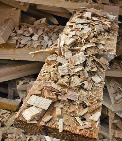 A vertical shot of leftover wooden chips and planks piled up outside